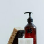 Aesthetic shot of dish soap, sponge, and soap bar on white backdrop.